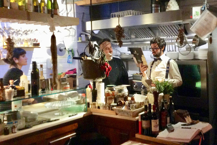 CoVino waiter Andreas (right) checks the evening's menu suggestions.